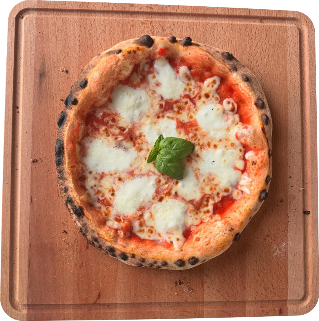 Pizza margherita met mozzarella en basilicum, net uit de oven op een houten plank